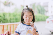 a little girl eating a chocolate popsicle 
