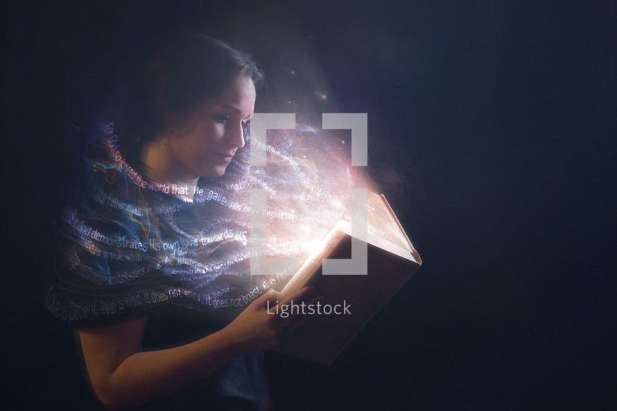a woman reading a glowing Bible 