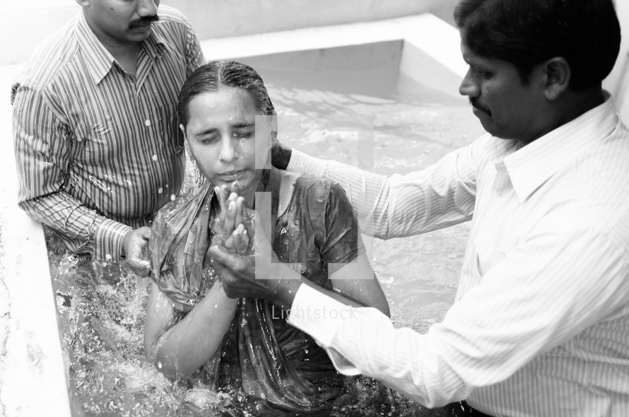 young woman being dunked in water during a baptism 