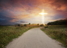 a cross of light at the end of a road 
