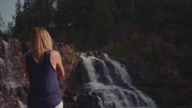 a woman watching a waterfall 