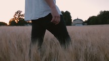 a man walking through a field of tall grasses 