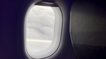Clouds passing by out the window of a plane