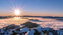 Sunrise morning panorama in cold sunny winter mountains with foggy clouds in valley nature Time lapse
