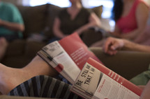 a group sitting on couches reading magazines