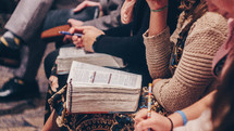parishioners with Bibles in their laps at church 