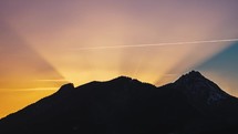 Last light of sunset behind alps mountains in beautiful evening nature time-lapse background
