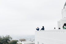 men taking pictures from a balcony 