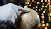Santa calculating his road on a World map globe 