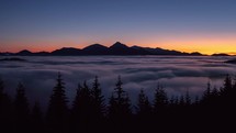 Beauty of Peaceful evening nature in summer mountains landscape after sunset above foggy clouds in forest Time lapse
