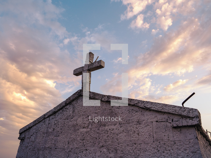 an old stone chapel with cross at dawn
