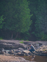 a man exploring a riverbed 