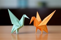 Two origami birds gracefully placed on a table, showcasing delicate paper folding artistry
