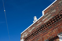 Lion statute on top of red brick building