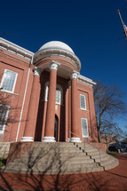 Red brick courthouse building with white dome