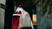Santa walking around a city on Christmas night 