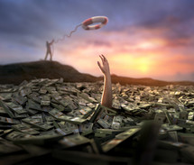 A person is struggling in a large amount of dollar bills, while someone on land is trying to rescue them.