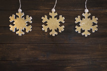 snowflake ornaments on a wood floor 