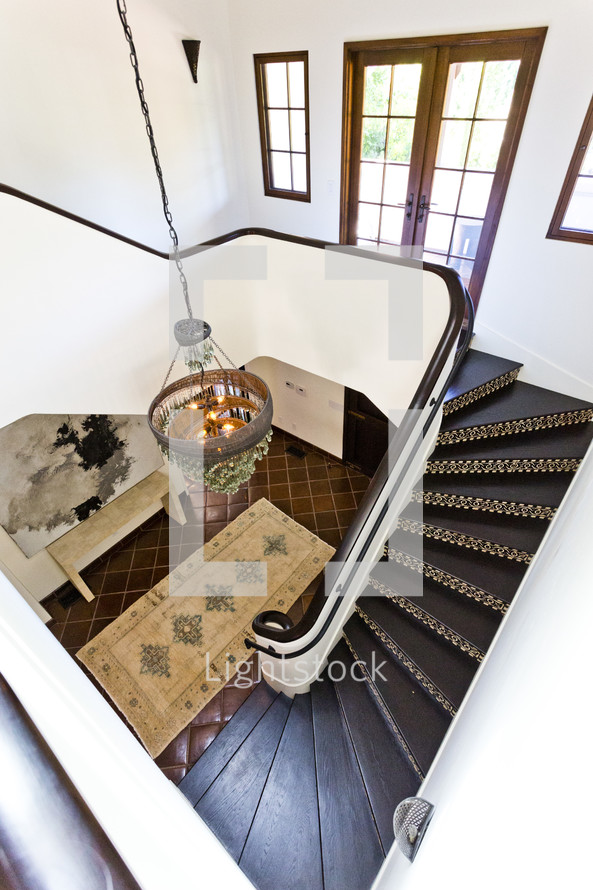 View of staircase, chandelier and foyer from upstairs spanish design decor style