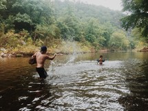 A man and a boy playing in a stream.