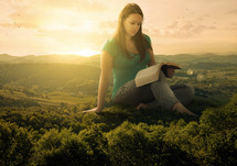 woman reading a Bible on a mountain top 