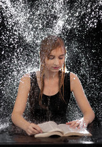 water raining down on a woman reading a Bible 