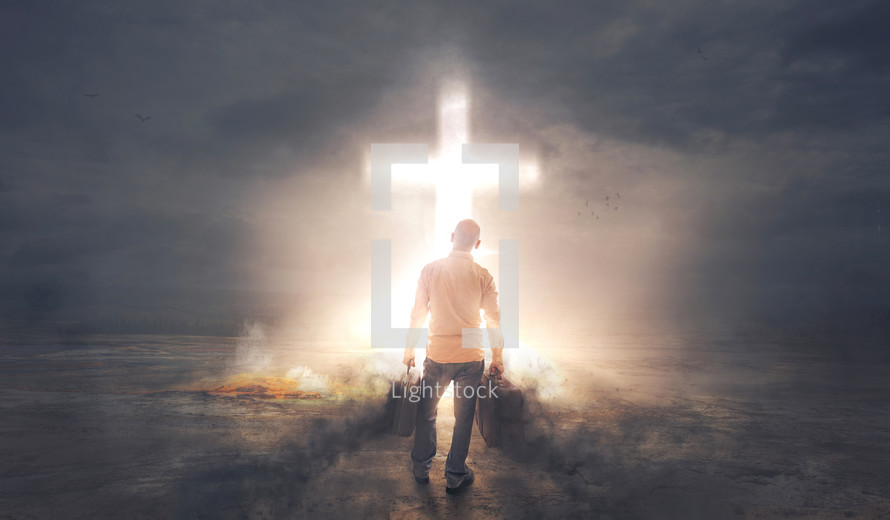 a man with baggage standing in front of a glowing cross