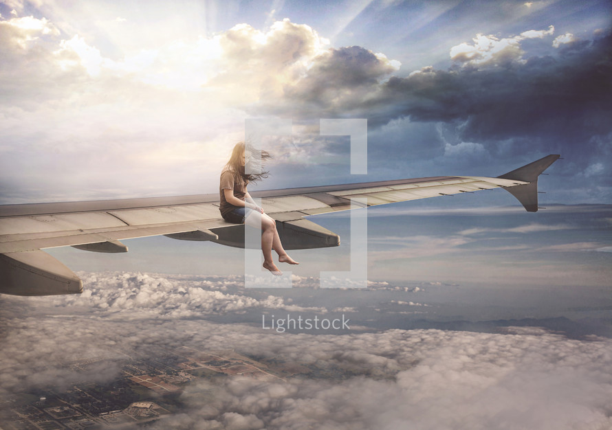 a woman sitting on the wing of an airplane 
