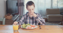 Young boy eating breakfast with healthy food.