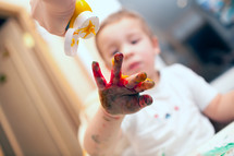Pressing finger-paint on boys hand