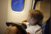 Boy in plane looking out illuminator