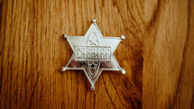 toy sheriff badge on a wood floor 