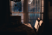 sunlight shining through blinds on a kitchen table and chairs 