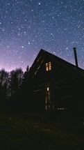 Stars moving over wooden hut shelter in peaceful night in wilderness forest nature Astronomy Timelapse Vertical
