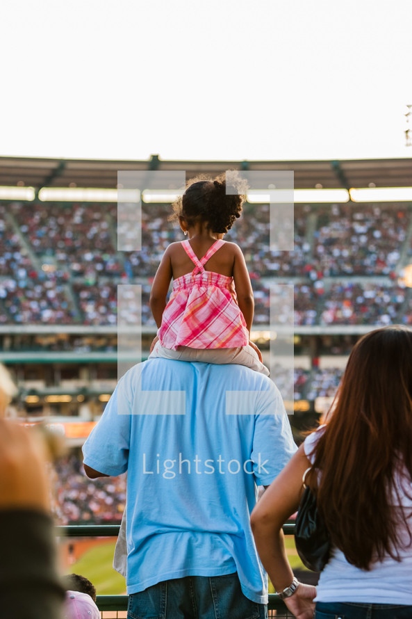 Young girl sitting on father shoulders at crusade dad 