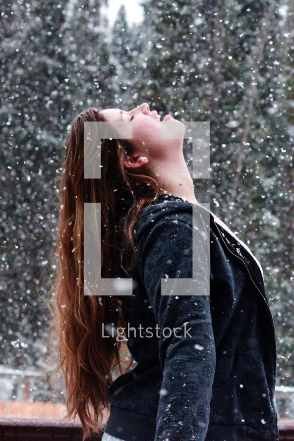 woman standing in falling snow 