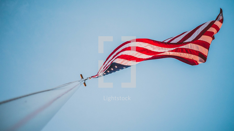 looking up at an American flag on a flag pole 