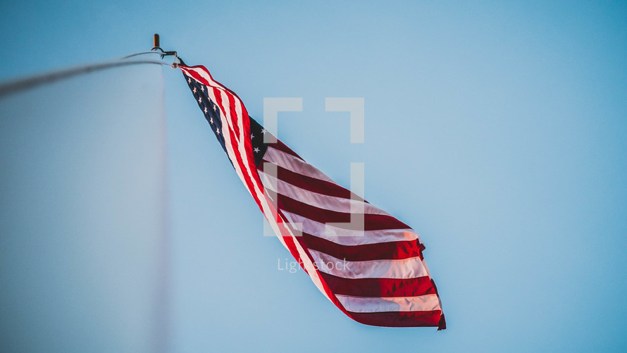 looking up at an American flag on a flagpole 