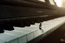 tiny woman sitting on piano keys