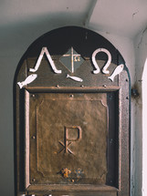 an old door to a chapel with greek christian symbols