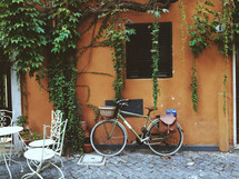 bike leaning against a wall and out seating on a patio 