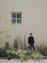 man standing outside by the side of a house 