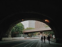 people walking through a tunnel in a city 