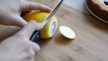 Woman cutting a lemon on the chopping board.