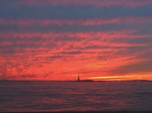 distant view of the Statue of Liberty at sunset 