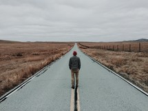 man standing in the middle of a road 
