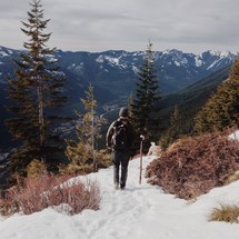 A man hiking in the snow on a mountain 