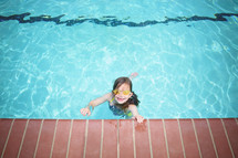 a girl child swimming in a pool 