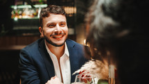 Man smiling at woman during romantic dinner