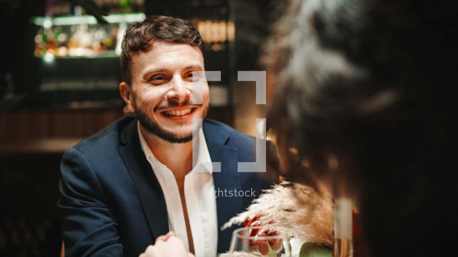 Man smiling at woman during romantic dinner